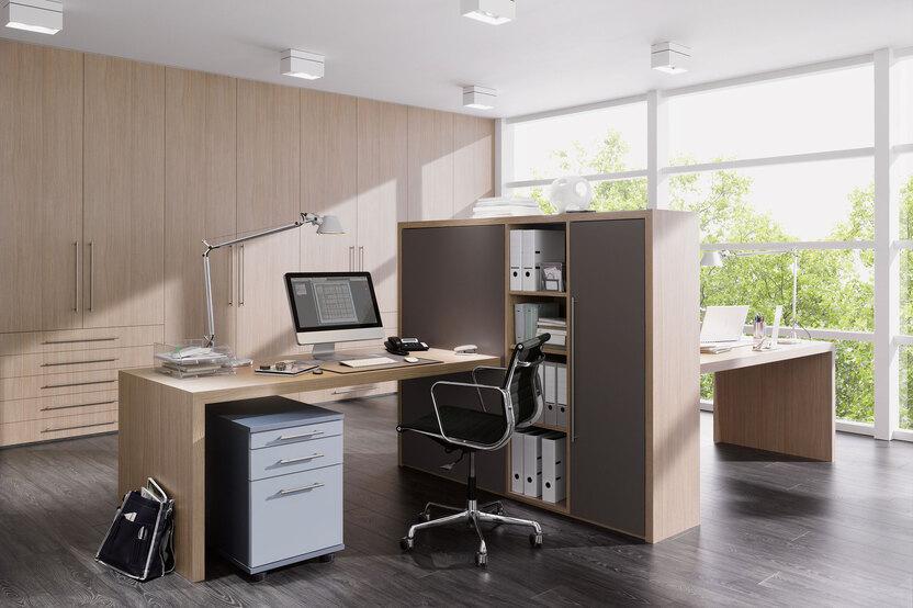 Impression von freistehenden Büromöbeln Impression von freistehenden Büromöbeln in L-Form mit hellem Einbauschrank im Hintergrund