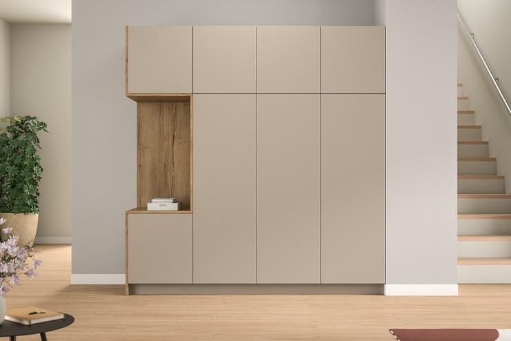 Maßgefertigter Schrank im modernen Eingangsbereich. Ein minimalistischer, maßgefertigter Schrank mit hellen und holzfarbenen Elementen, integriert neben einer Treppe, bietet stilvollen Stauraum im Eingangsbereich.