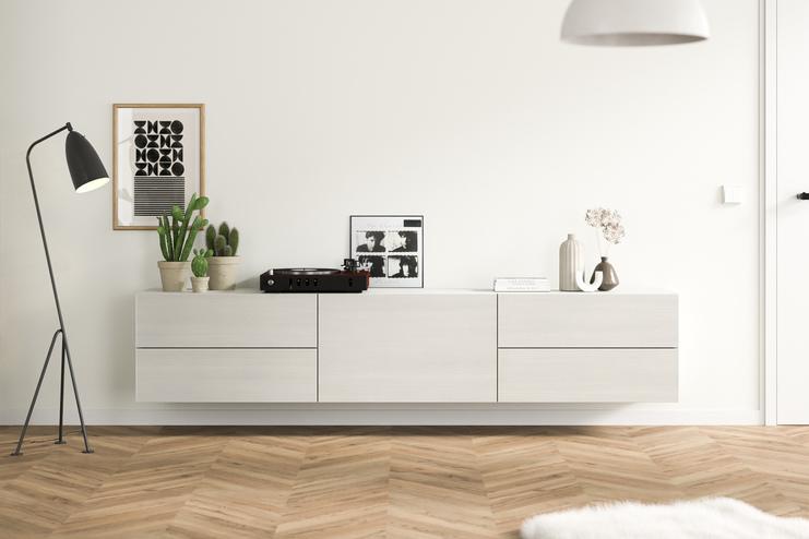 Helles Hängeboard nach Maß im modernen Wohnzimmer Ein maßangefertigtes, wandmontiertes Hängeboard in schlichtem Weiß, ergänzt durch zeitgenössische Deko und Grünpflanzen, fügt sich nahtlos in ein gemütliches Wohnambiente ein.
