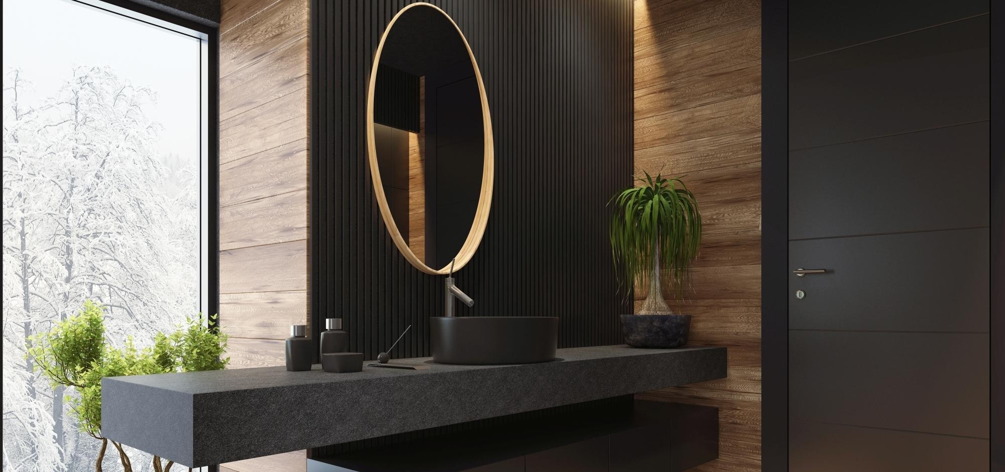 Badimpression mit dunklem schwarzem Waschtisch und Unterschrank Lichtdurchflutetes Badezimmer mit dunkler schwarzer Waschtischarbeitsplatte, die über die Wand hinausragt und hängendem Unterschrank, runder Spiegel, Wandkontrast in Holz.
